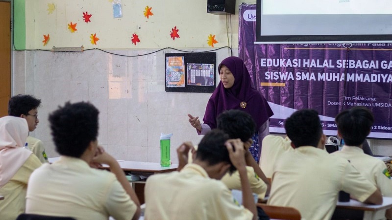 Ketua Abdimas Risetmu Umsida Ima Faizah memberikan materi edukasi halal di SMA Muhammadiyah 2 Sidoarjo. Dosen Umsida Edukasi Gaya Hidup Halal di Smamda (Ario Khairul Habibn/PWMU.CO)